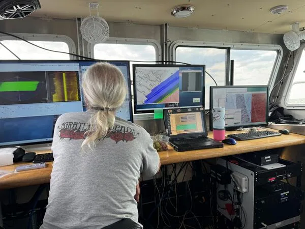 Ilmuwan meninjau data pemetaan dasar laut di atas kapal riset